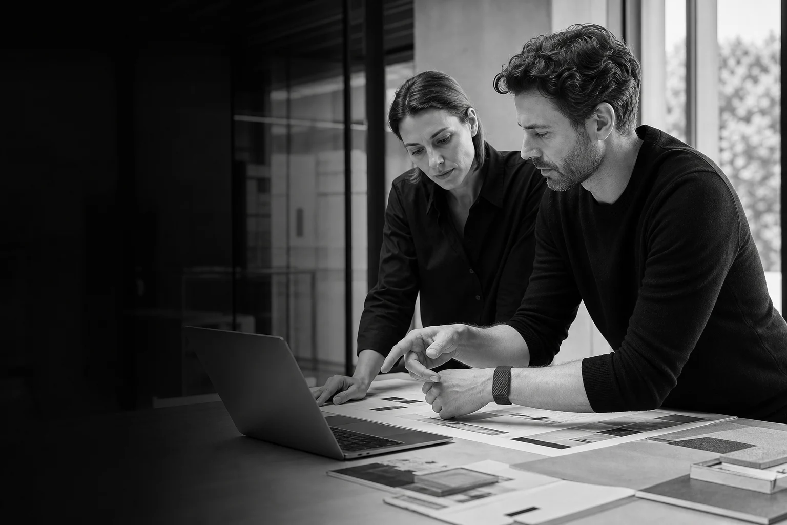 Two creative professionals reviewing a presentation in a modern studio with BEFORE.Band worn naturally at the wrist
